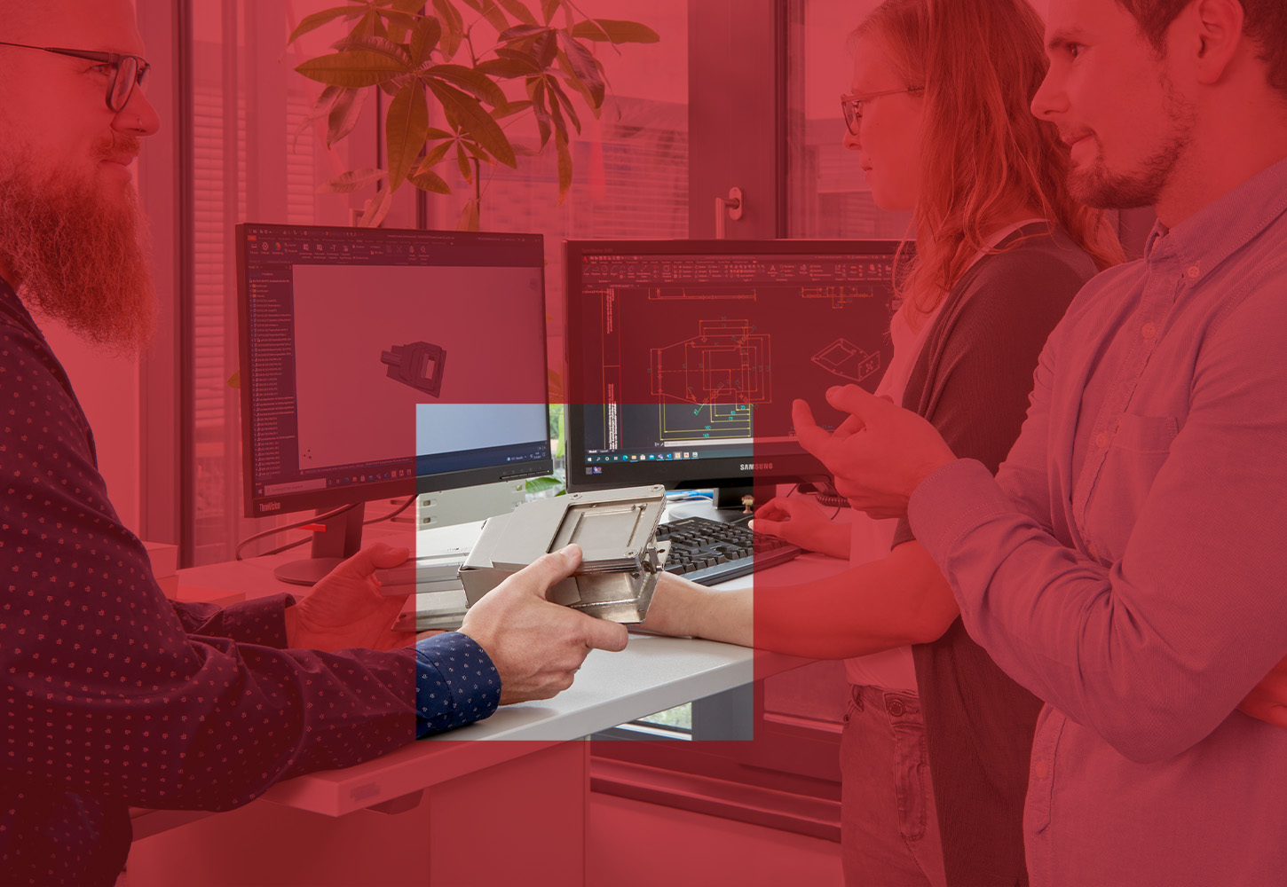 Kolleg:innen stimmen sich im Büro über ein technisches Projekt ab